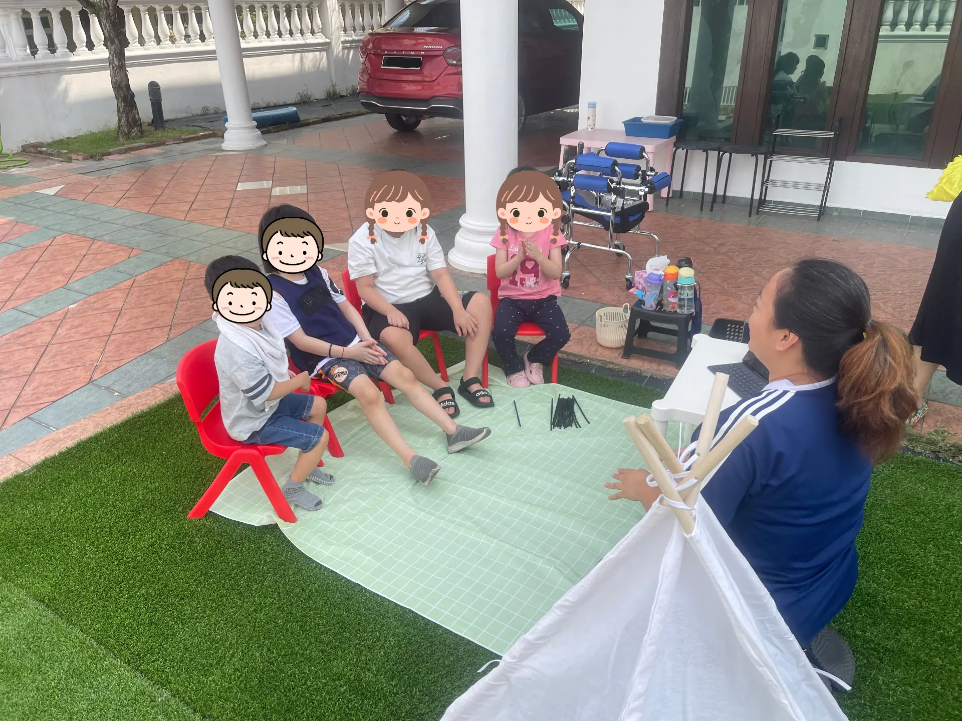 Children playing with a small basketball and a fabric tent on the grass.