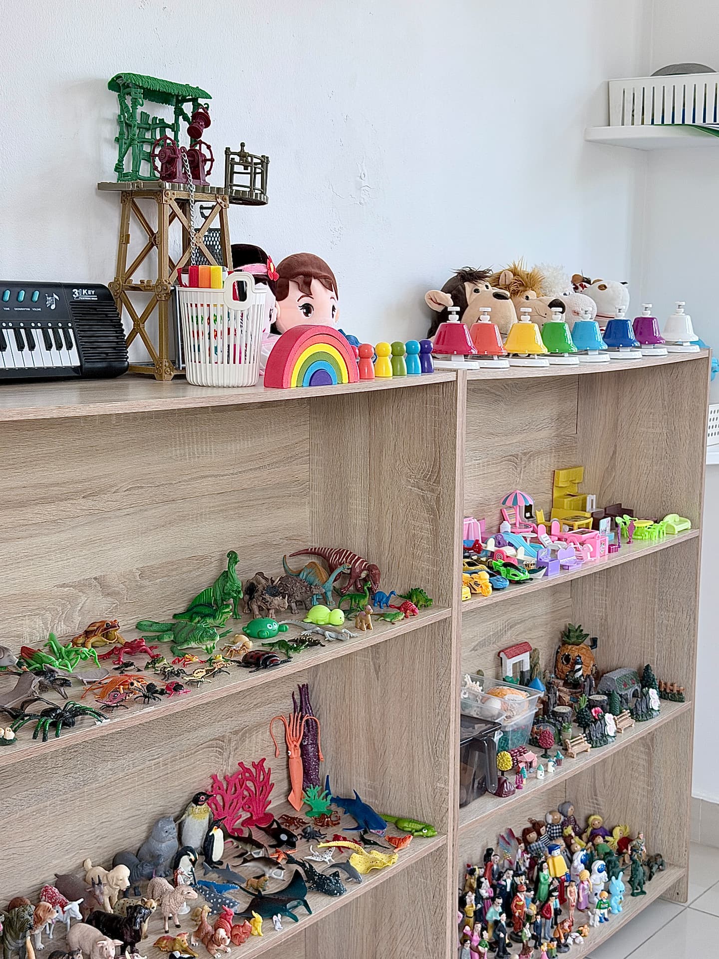 Shelves filled with animal figurines, sea creatures, musical bells, and a keyboard.