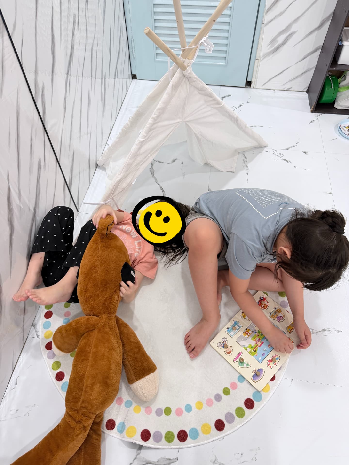 Two children relaxing and doing puzzles inside a cosy play tent.