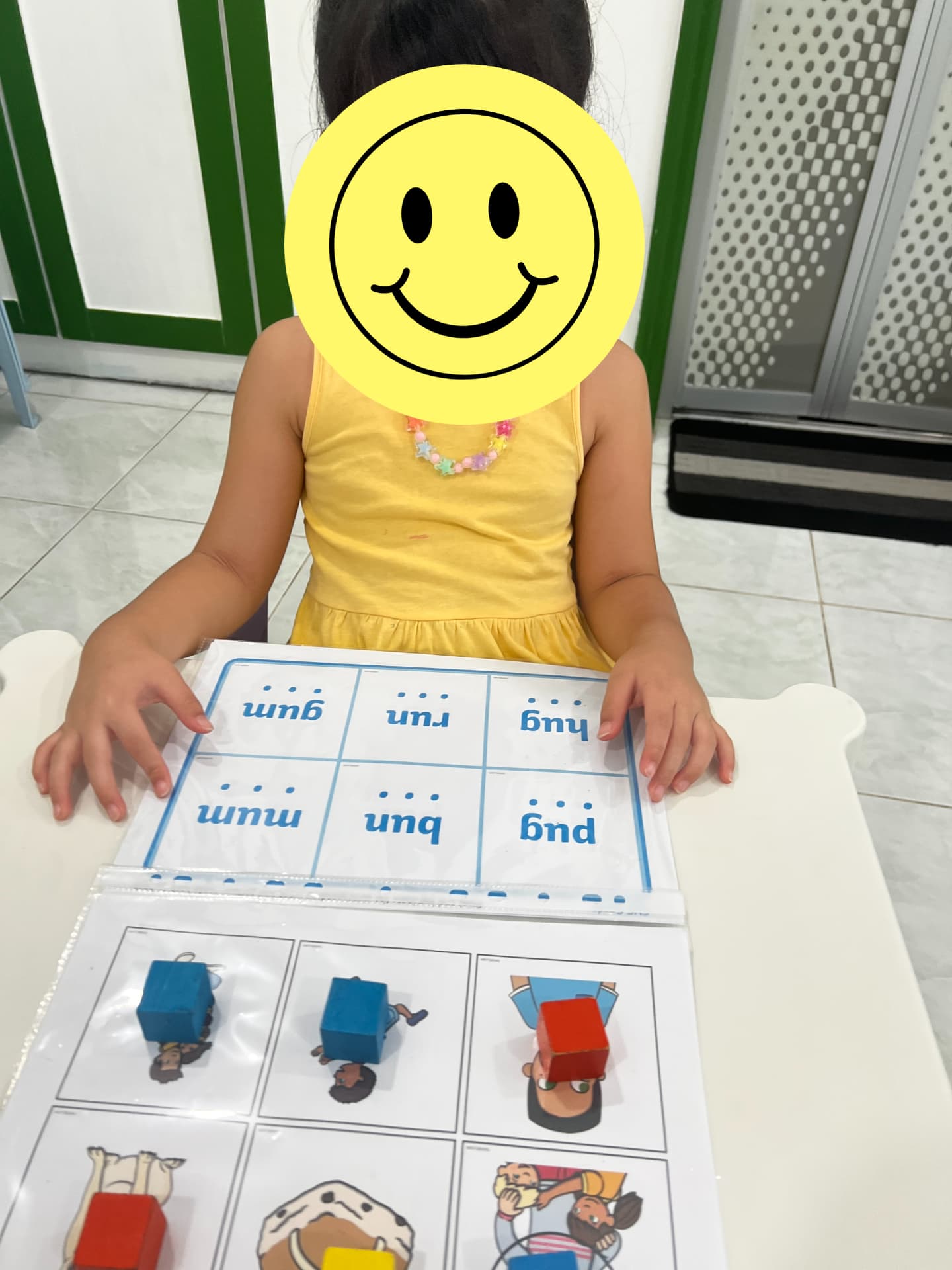 A child working with a picture and word matching activity book.